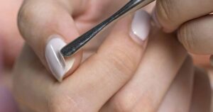 Close-up of manicure process pushing back cuticles