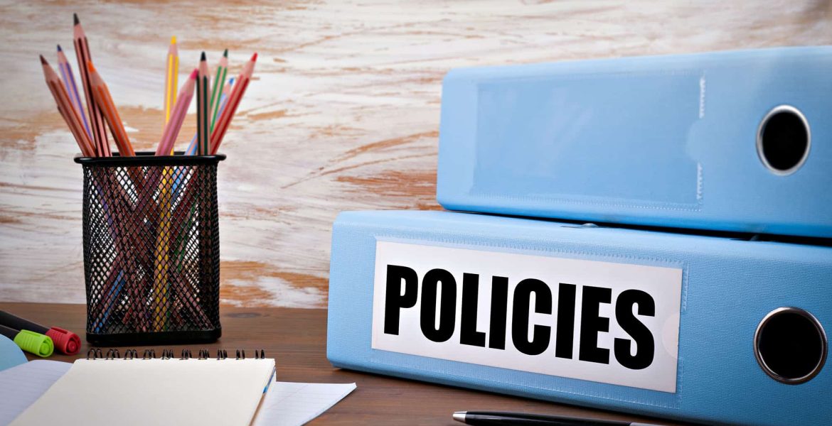 Office desk with policy binders, notepad, and stationery