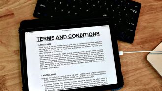 Tablet displaying terms and conditions on a wooden table