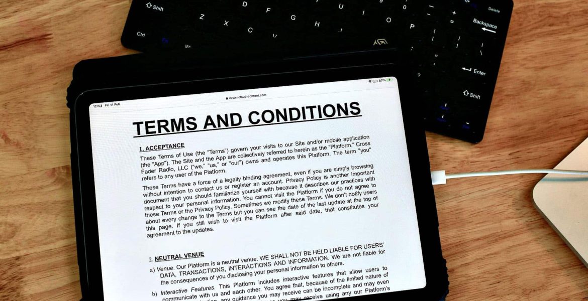 Tablet displaying terms and conditions on a wooden table