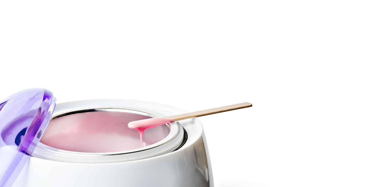 Electric wax warmer with pink wax and wooden applicator